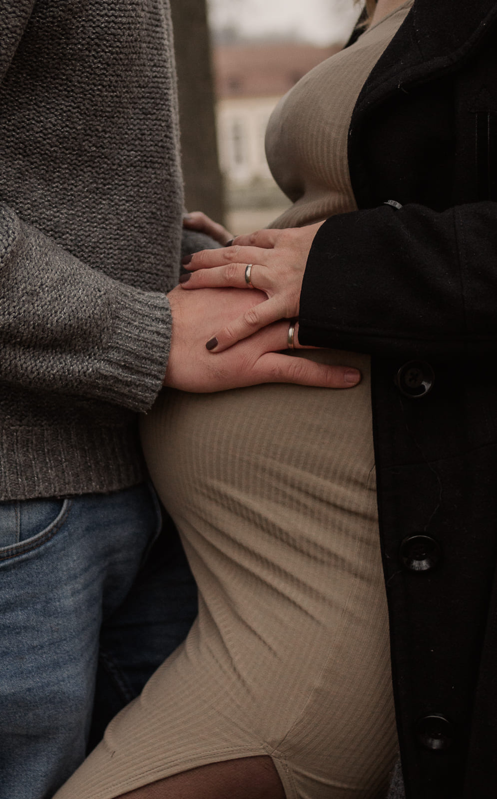 Babybauch Fotoshooting bei Ansbach – Hände eines Paares liegen liebevoll auf dem Bauch