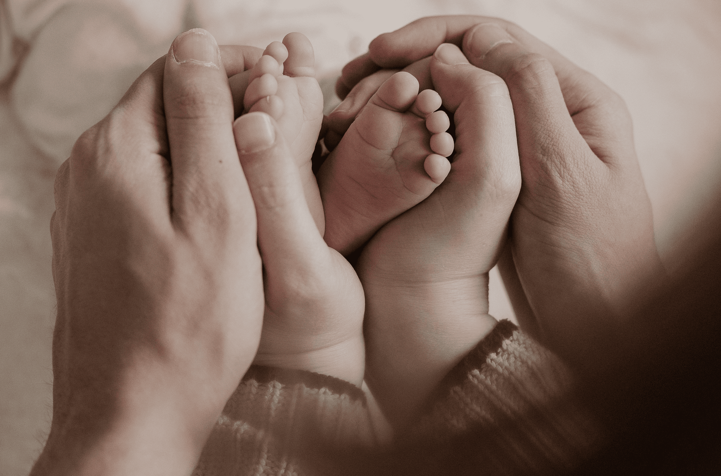 Neugeborenenfotografie Ansbach – Babyfüße in den Händen der Eltern, liebevolles Newbornshooting zuhause