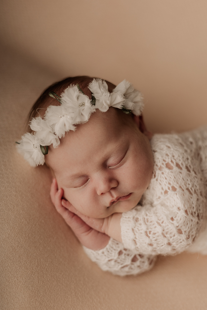Neugeborenenfotografie Ansbach – schlafendes Baby mit Blumenkranz in natürlicher, zarter Newborn Fotografie