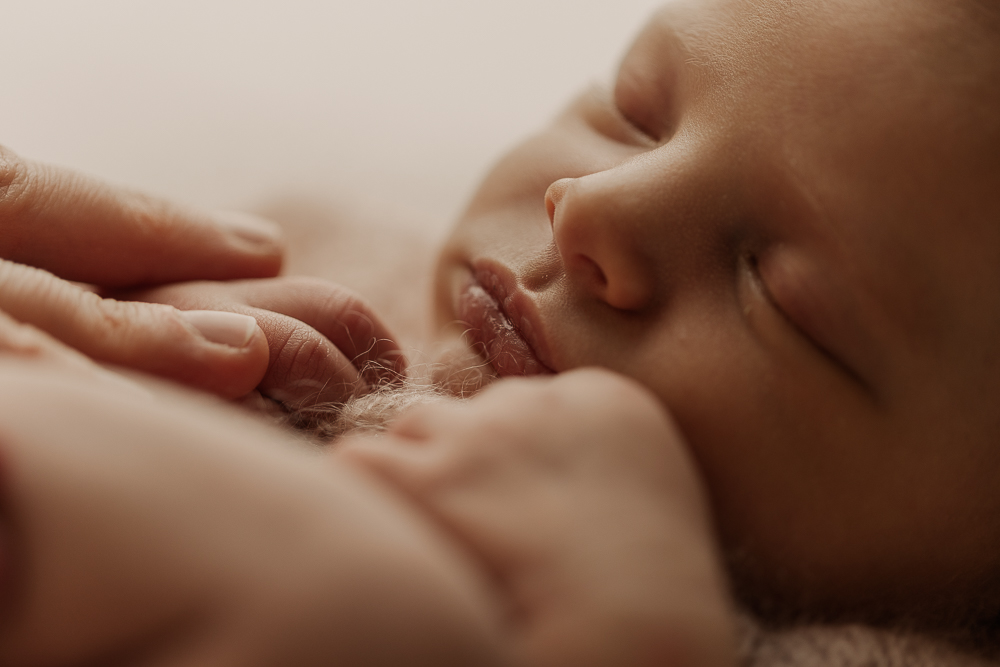 Neugeborenenfotografie Ansbach – Detailaufnahme eines schlafenden Babys mit zarten Händen, natürliche Newborn Fotografie